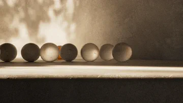Warm monochrome study of a row of small spheres resting on a ledge in Marble Run.